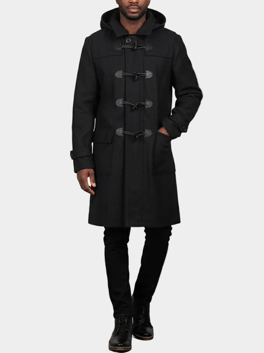 Man wearing a black duffle coat on a plain background